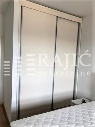 A bedroom with a large built-in wardrobe and a bed.