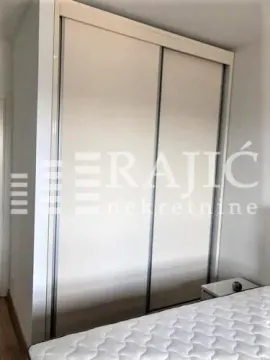 A bedroom with a large built-in wardrobe and a bed. - image 7