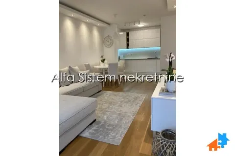 Living room with a sofa set, dining area, and fitted kitchen in the background. - image 5