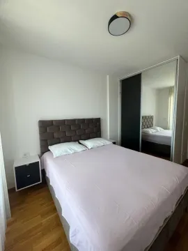 Bedroom with a double bed, nightstand, and built-in wardrobe with a mirror. - image 4