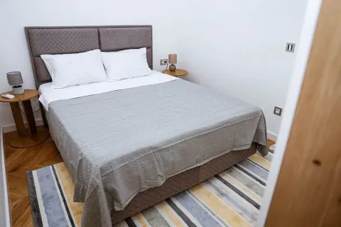 Uređena spavaća soba sa bračnim krevetom i noćnim stočićima. - image 11