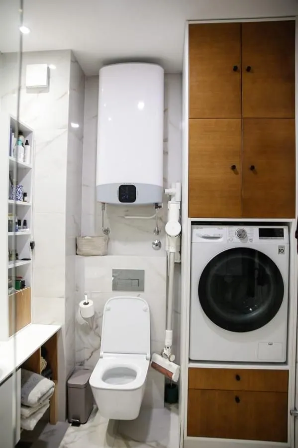 Kupatilo sa wc šoljom, bojlerom i ugrađenom veš mašinom.