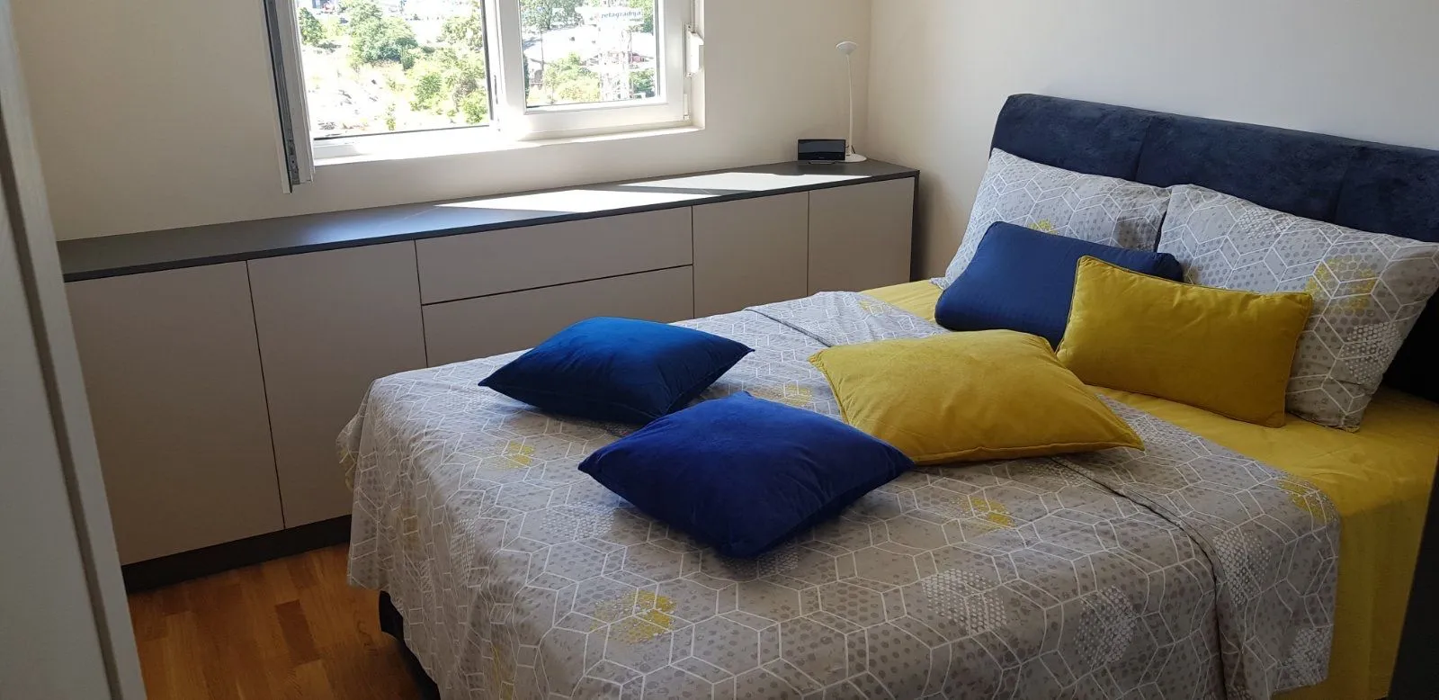 Furnished bedroom with a double bed and a window.
