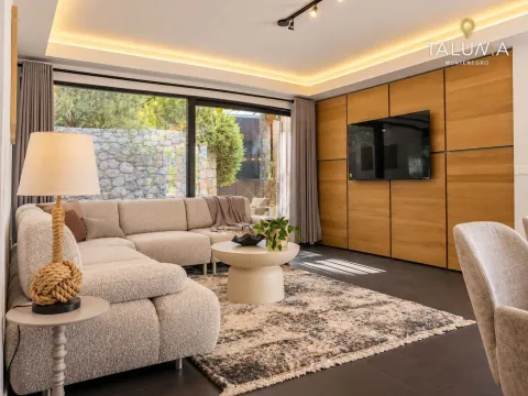 Modern living room with a sectional sofa, wooden wall panels, and large glass surfaces. - image 9