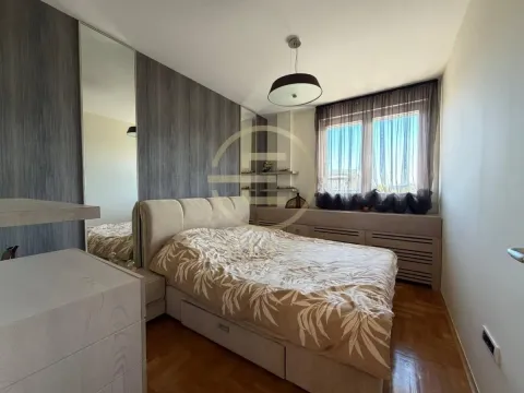 Nameštena spavaća soba sa bračnim krevetom, plakarom sa ogledalom i prozorom. - image 21