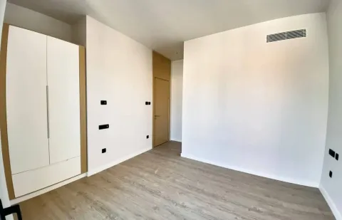 Prazna soba sa bijelim zidovima, ugradnim ormarom i drvenim podom. - image 18