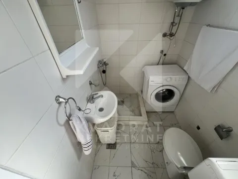 Smaller bathroom with a shower enclosure, washbasin, and washing machine. - image 6