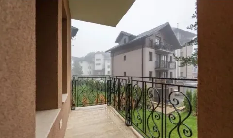 Natkriveni balkon sa kovanom ogradom i pogledom na susedne zgrade. - image 15