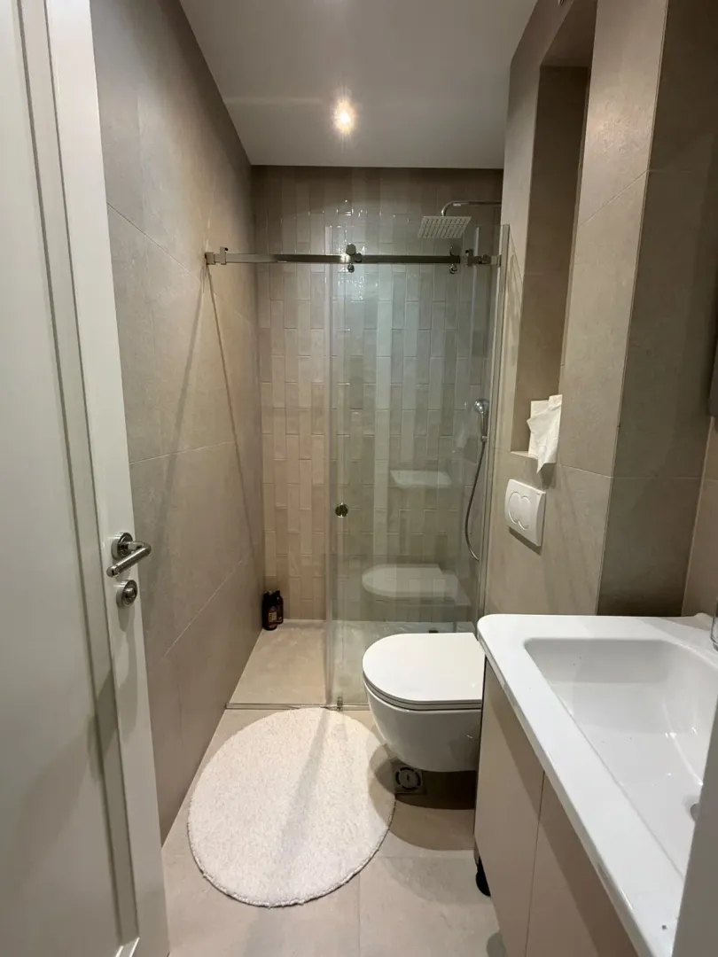 Modernly equipped bathroom with a shower cabin and a sink.