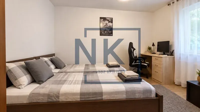 Furnished bedroom with two beds and a desk.