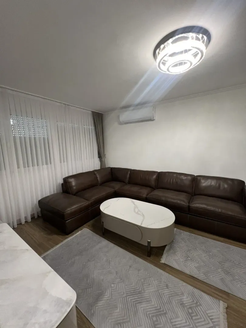 Bright living room with a leather sectional sofa and a coffee table.