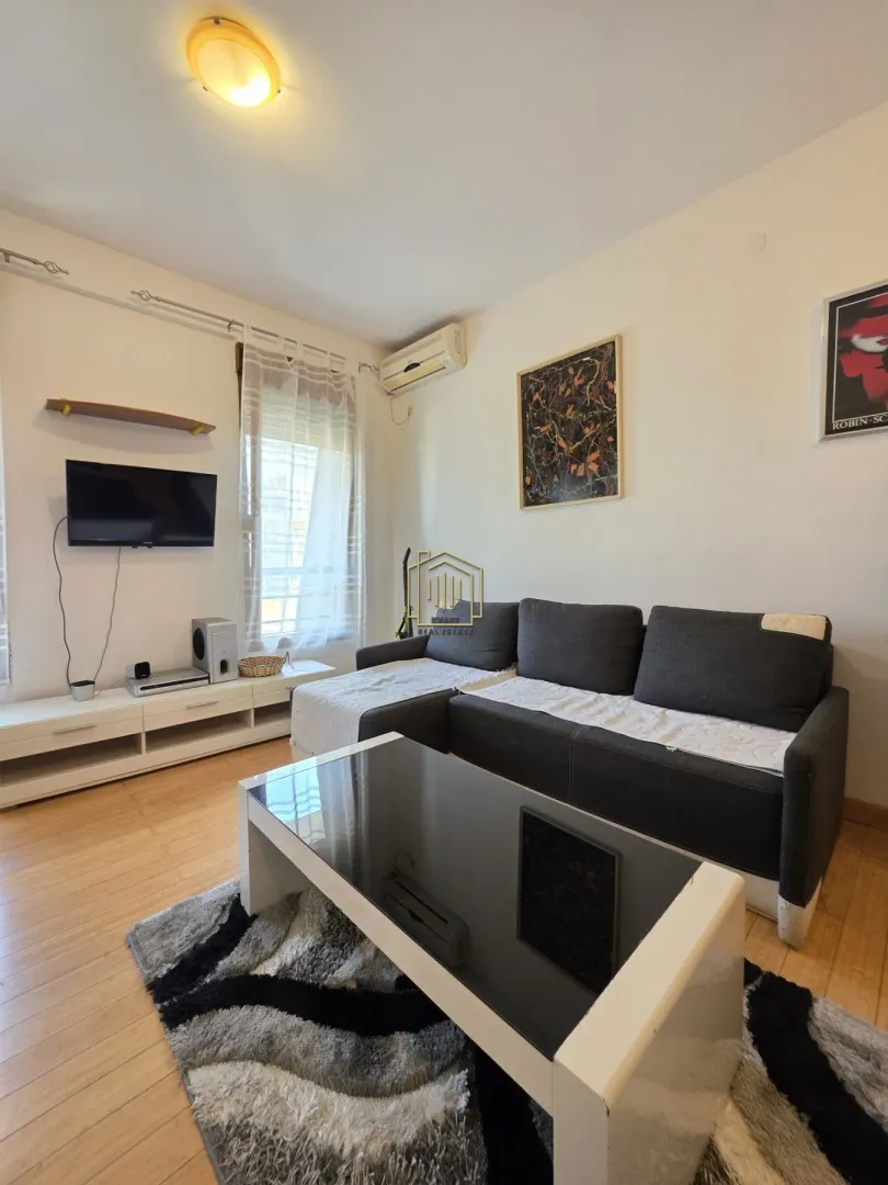 Living room with a sofa, TV, and coffee table.