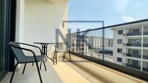 Namtješten balkon sa stolom i dvije stolice i pogledom na okolne zgrade. - image 2