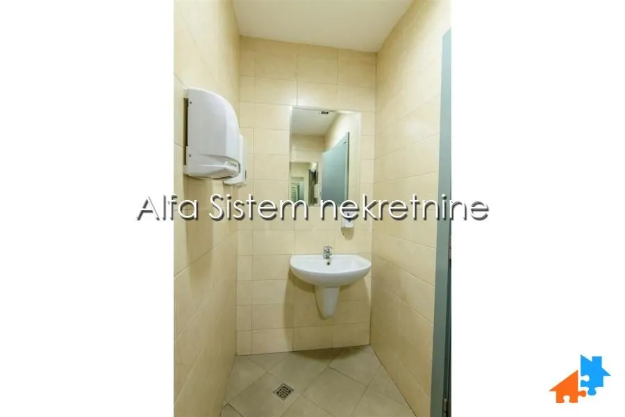 View of the bathroom with a sink, mirror and tiles.