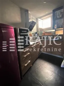 Small kitchen with wooden elements and a red refrigerator. - image 5