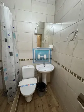 Smaller bathroom with a shower, washbasin, and toilet. - image 31