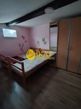 Spavaća soba sa dva kreveta i drvenim ormarom. - image 5