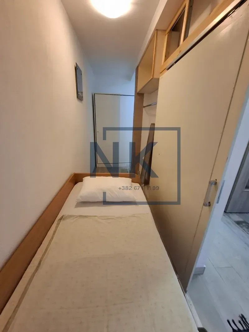 Small bedroom with a bed and a wardrobe.