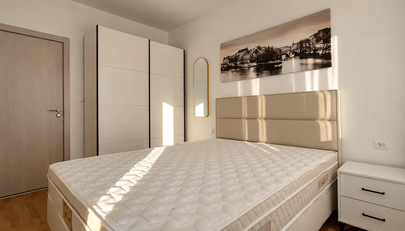 Bedroom with a double bed, white wardrobe, and a bedside table.