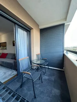 Covered balcony with outdoor seating and a view of the surroundings. - image 9