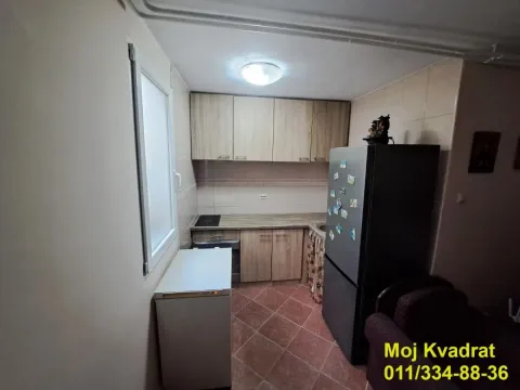 Manja kuhinja sa drvenim elementima i frižiderom. - image 4
