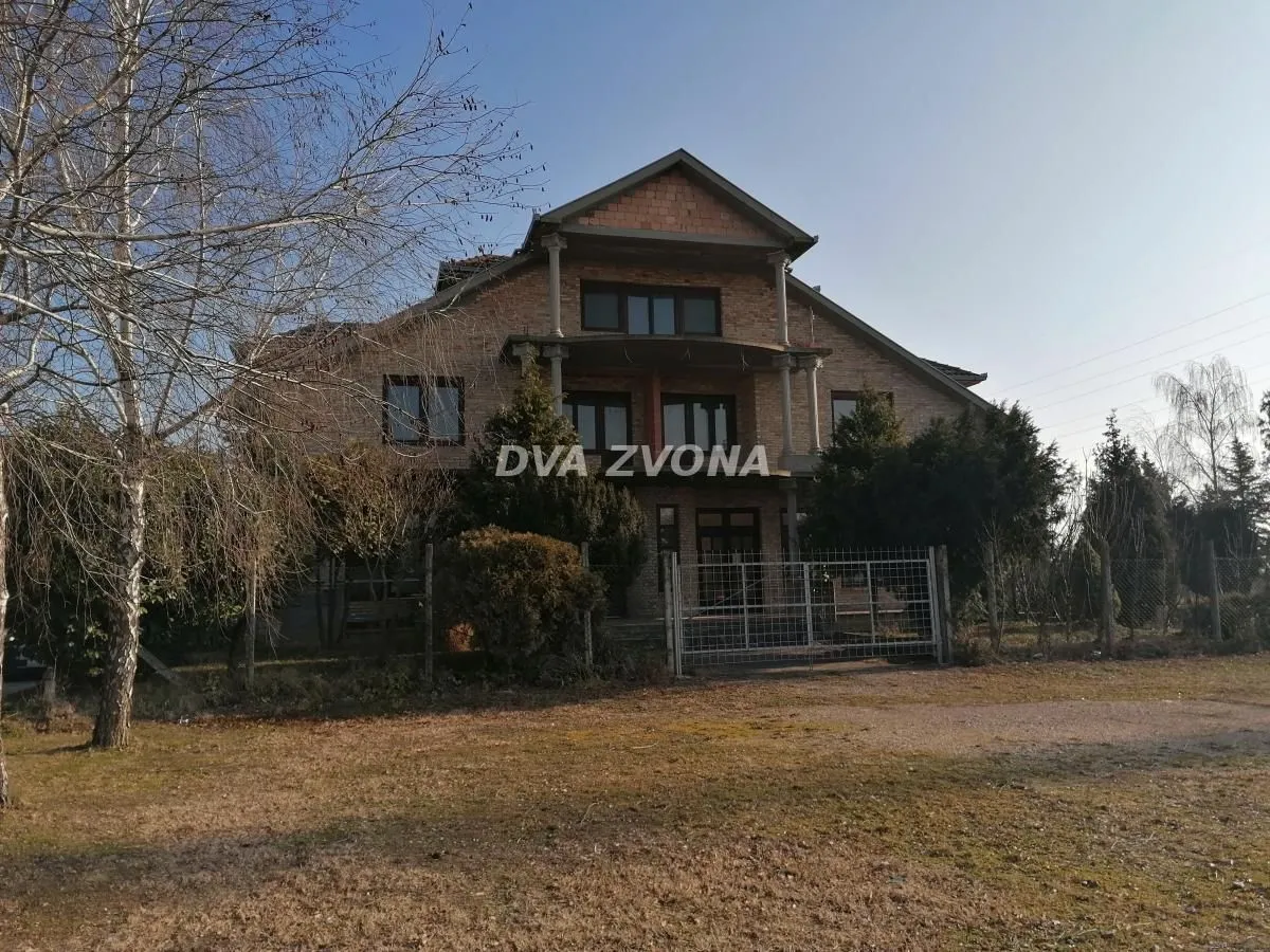 Exterior view of the house with a yard and a fence.