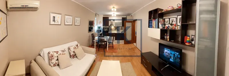Dnevna soba povezana sa trpezarijom i kuhinjom u pozadini.