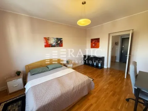 Furnished bedroom with a double bed, desk, and parquet flooring. - image 8