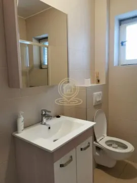 Bathroom equipped with a vanity unit with sink, mirror, and toilet. - image 14
