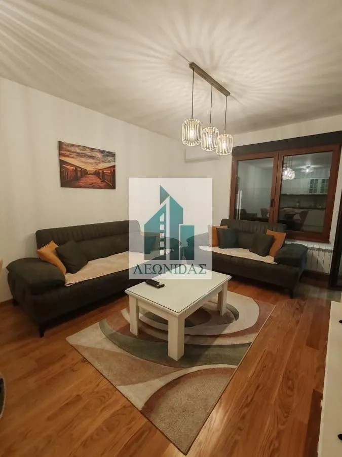 Living room with a sofa, coffee table and rug.
