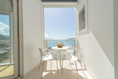 Bright and tidy balcony with a table, chairs, and a sea view. - image 2