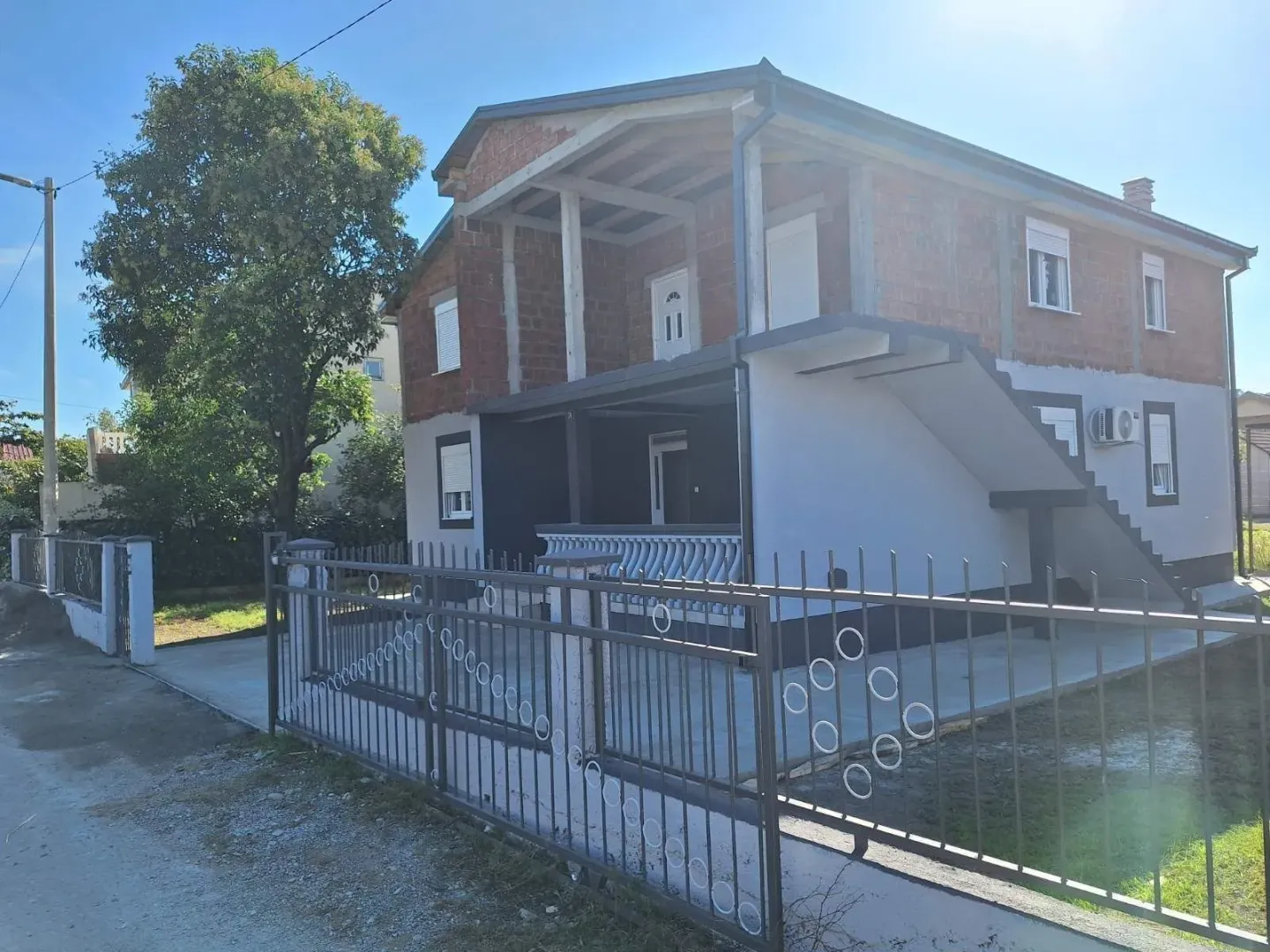 Exterior of a two-story house under construction with a yard.