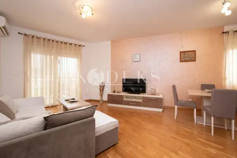Living room with sofa, TV unit, and dining table. - image 2