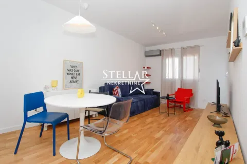 Living room with a dining table, sofa, and TV unit. - image 3