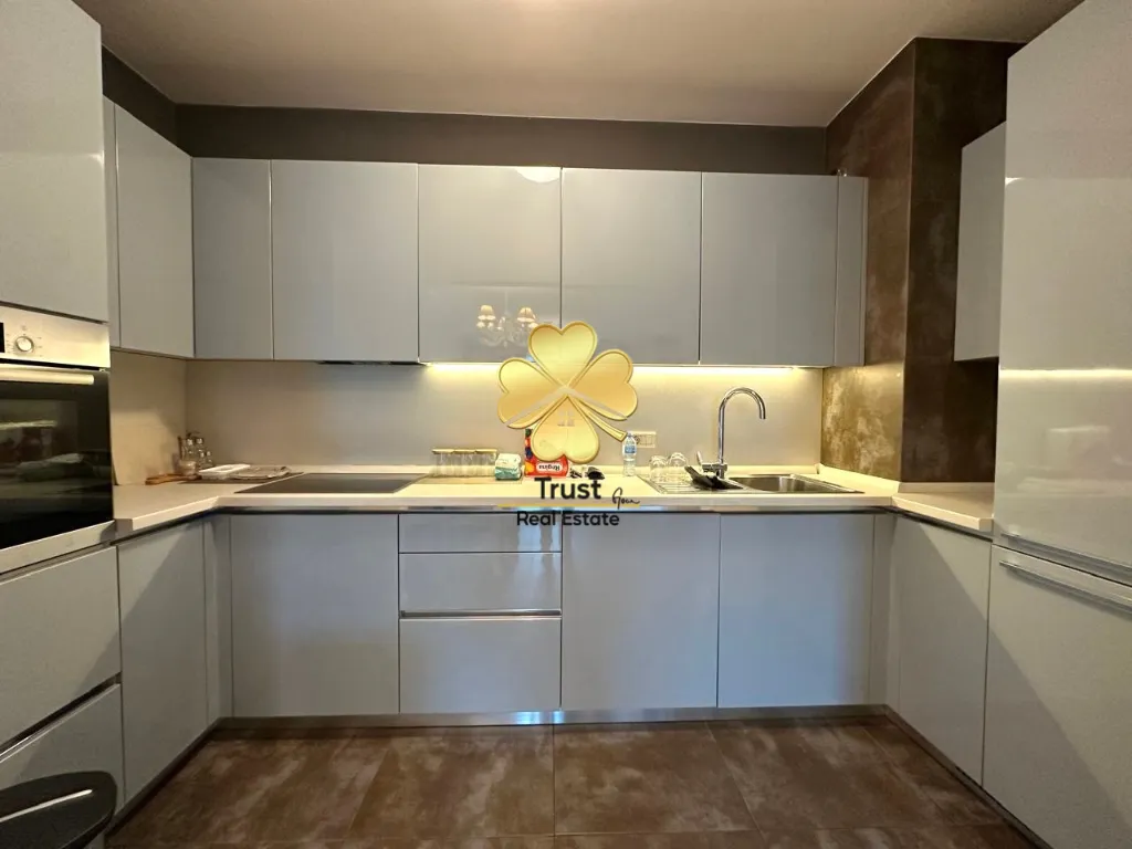 Modern kitchen with light cabinetry and built-in appliances.