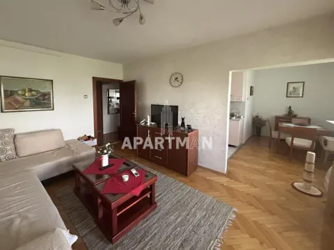 Dnevna soba sa garniturom, stočićem i televizorom, sa pogledom na trpezariju. - image 2