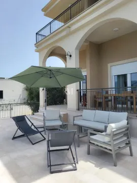 Terrace with outdoor seating furniture and an umbrella in front of the house. - image 4