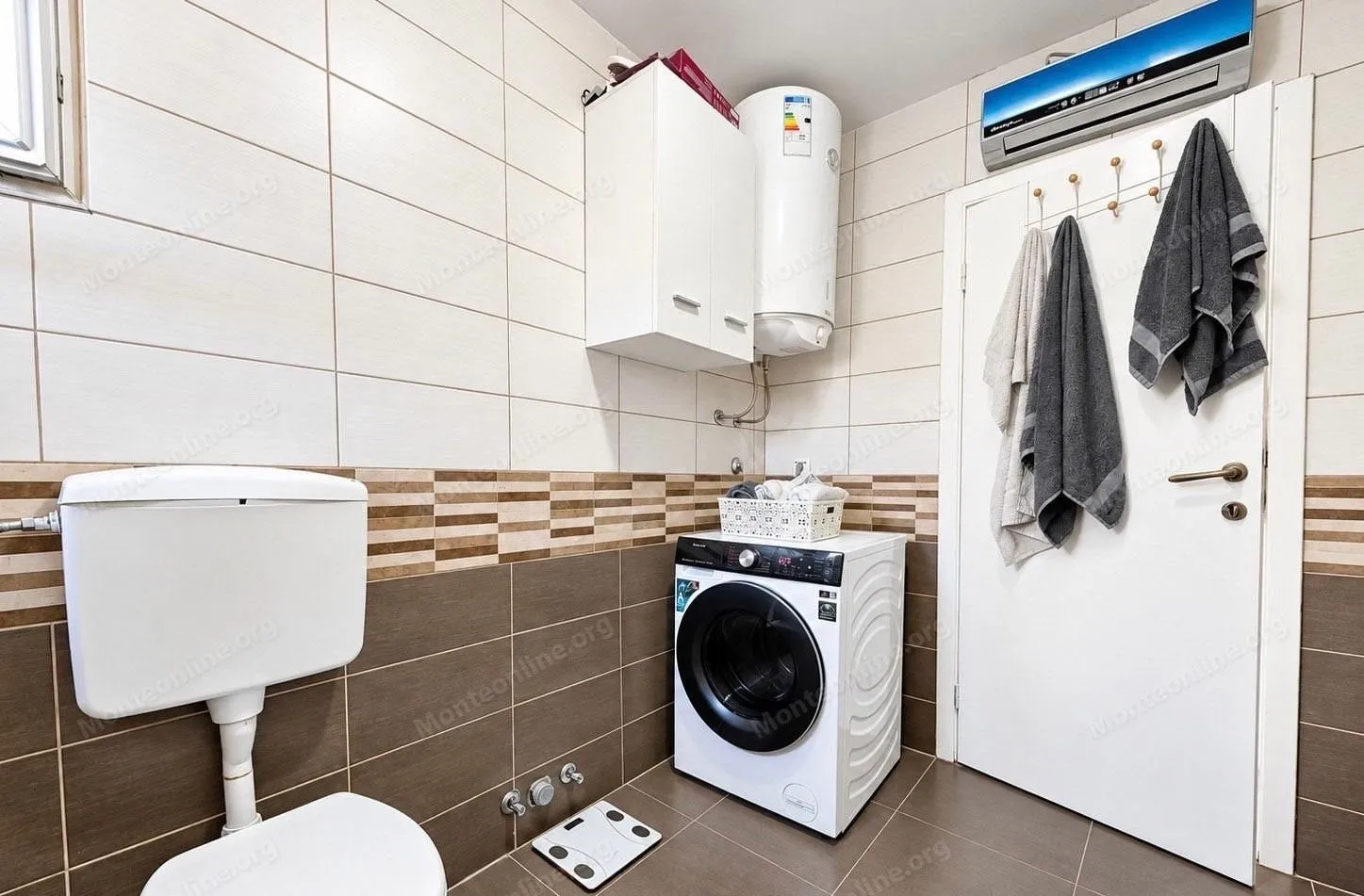 Bathroom equipped with sanitary ware, washing machine, and a white cabinet.