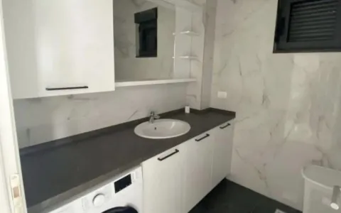 Moderne kupatilo sa bijelim namještajem, umivaonikom i ugrađenom mašinom za veš. - image 6