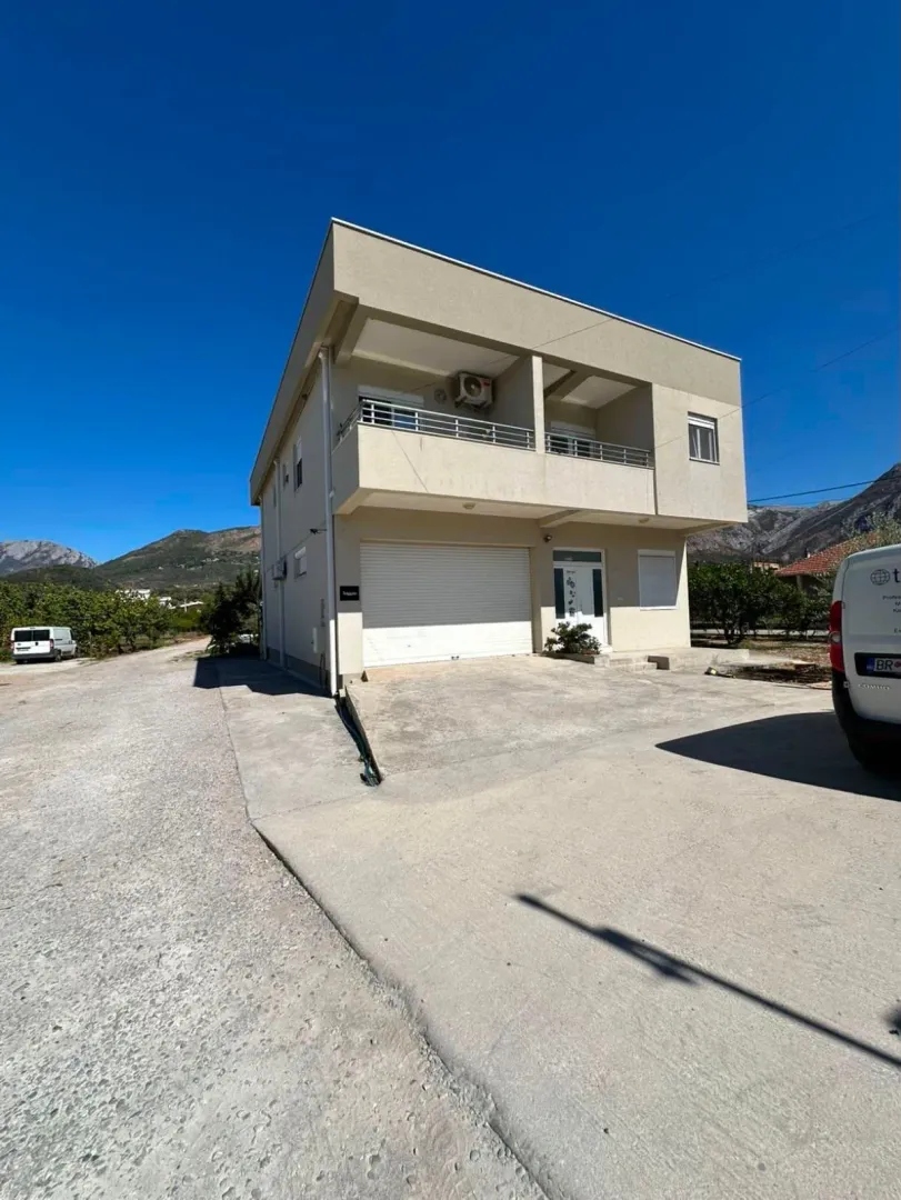 Exterior view of a two-story house with a yard and mountain views.