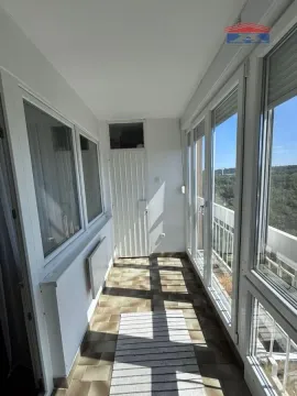 Zastakljeni balkon sa pločicama na podu i pogledom na prirodu. - image 3