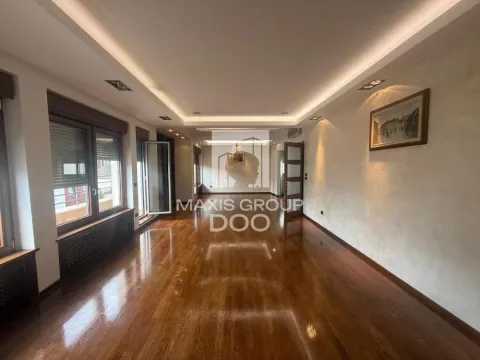 Spacious empty living room with wooden flooring and a drop ceiling with lighting. - image 3