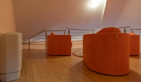 Dnevni boravak sa narandžastim foteljama i drvenim podom u potkrovlju. - image 15