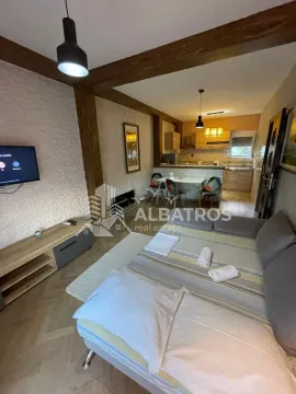 Living room with a bed, TV, and a view of the kitchen with dining area. - image 15