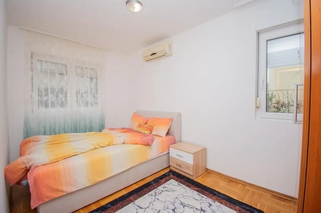 Bright bedroom with a single bed and air conditioning.
