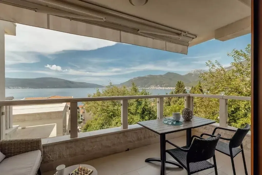 Namješten balkon sa garniturom za sjedenje i pogledom na more.