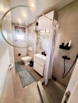 Smaller bathroom with a shower cabin, washbasin, and toilet. - image 7