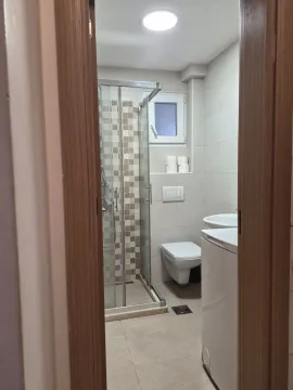 Pogled na kupatilo sa tuš kabinom kroz otvorena vrata. - image 6