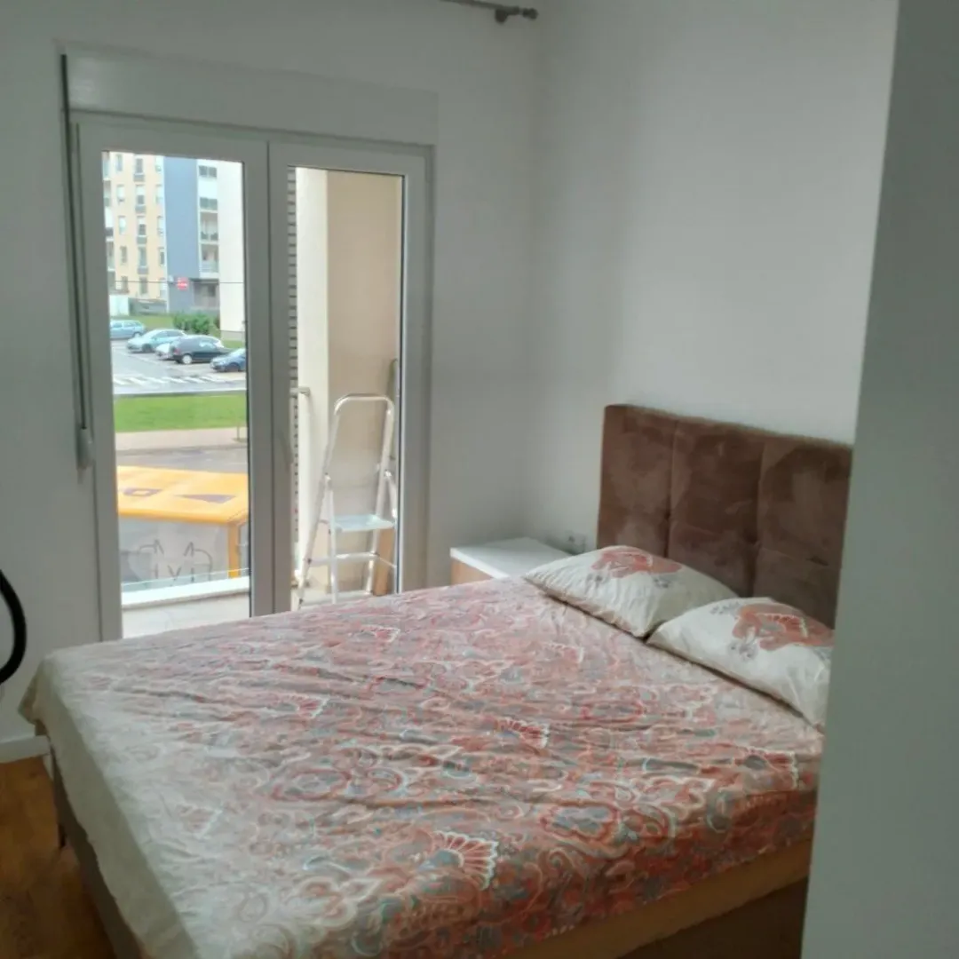 Bright bedroom with a double bed and balcony access.