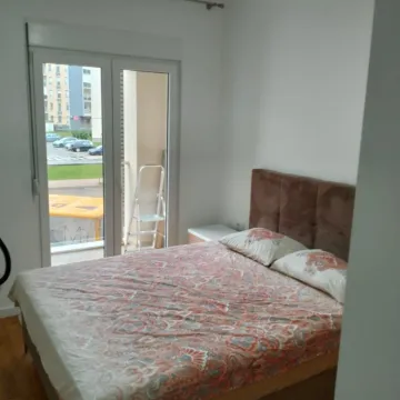 Bright bedroom with a double bed and balcony access. - image 7